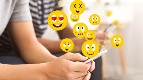 Emojis schweben über Smartphone