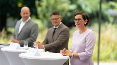 Pressekonferenz Kloster Eberbach Zwei Männer und eine Frau stehen an Pult.