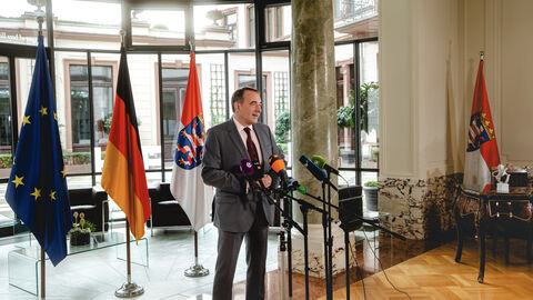 Finanzminister Alexander Lorz im Interview vor dem Rüstungsgipfel. Finanzminister Alexander Lorz steht vor Mikrofonen in einer Interviewsituation.