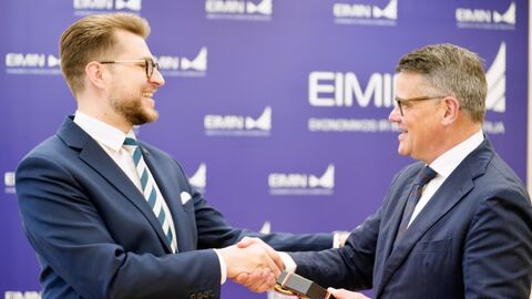 Zwei Männer stehen sich gegenüber und schütteln sich lächelnd die Hände.