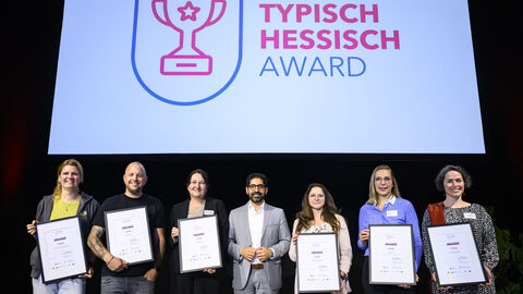 Die Nominierten für den "Typisch Hessisch" Award Mehrere Personen stehen mit Urkunden in der Hand auf einer Bühne